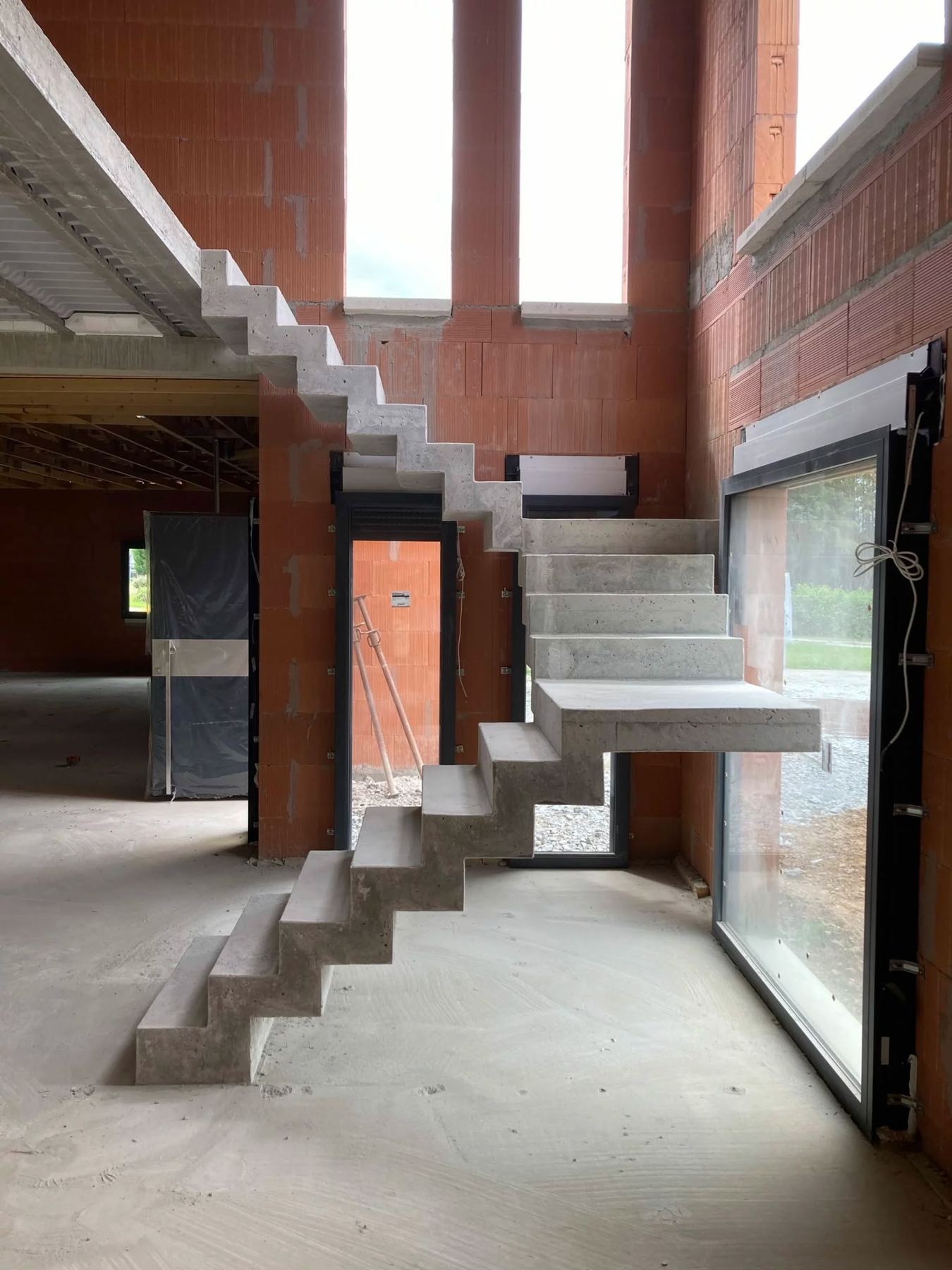 Escalier en béton à crémaillère dans une maison en brique en cours de construction