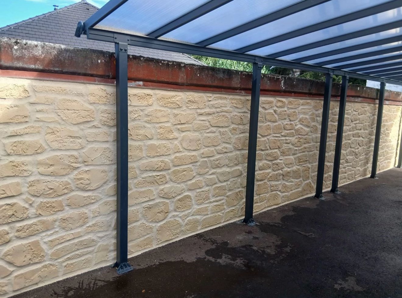 Après : mur recouvert d'un enduit décoratif façon pierre sous le carport